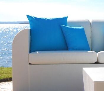 Cojines azules para exterior en un sofa en un jardin de Malaga